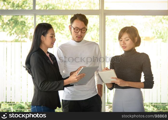 young asian business people, man and woman, working with team in startup office
