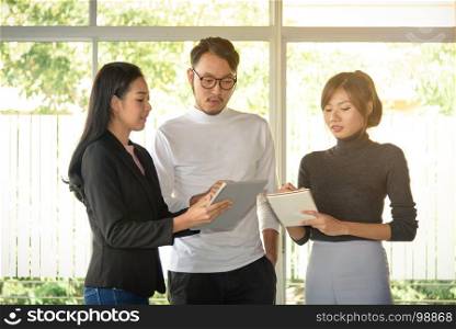 young asian business people, man and woman, working with team in startup office