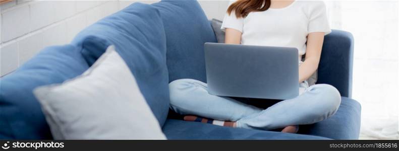 Young asian business woman in face mask work from home on laptop computer online to internet in living room, girl in medical mask and quarantine for pandemic of covid-19, stay home, new normal.
