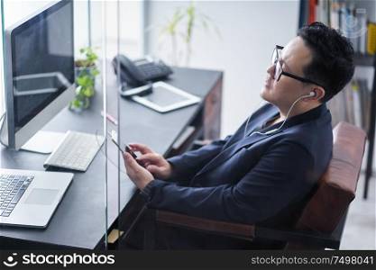 Young asian businessman listening music for relax