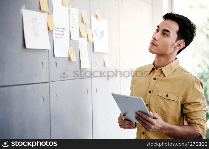 Young Asian Businessman Working on Digital Tablet in Office Meeting Room. Man Analyzing Data Plans and Project