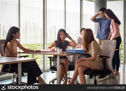 young asian businesspeople, man and woman, working with team in startup office, selective focus