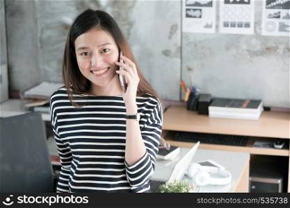Young asian businesswoman talking smart phone smiling with happy emotion, working at home, office casual lifestyle concept