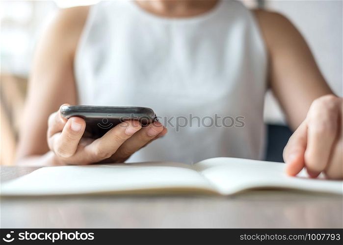Young Asian Businesswoman using mobile phone in office, woman sitting and hand touching screen on cellphone. Smart business and Technology concepts
