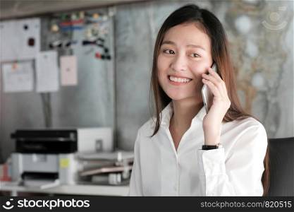 Young asian businesswoman working and talking phone at office table, business casual lifestyle