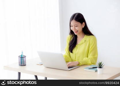 Young asian businesswoman working on laptop computer on desk at home office, freelance looking and typing on notebook on table, lifestyle of woman studying online, business and education concept.