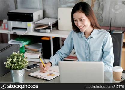 Young asian businesswoman working with laptop computer at office with happy emotion, working at home, office casual lifestyle concept