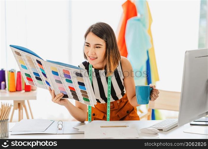 Young Asian designer woman choosing multicolor chart and holding coffee cup at workplace, small business startup, Business owner entrepreneur, modern freelance job lifestyle concept. asean people