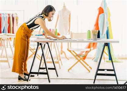 Young Asian designer woman working with computer and choosing multicolor chart at workplace, small business startup, Business owner entrepreneur, modern freelance job lifestyle concept. asia people