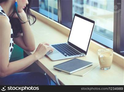 Young asian fashionable businesswoman using computer laptop at the office or cafe, business and startup concept