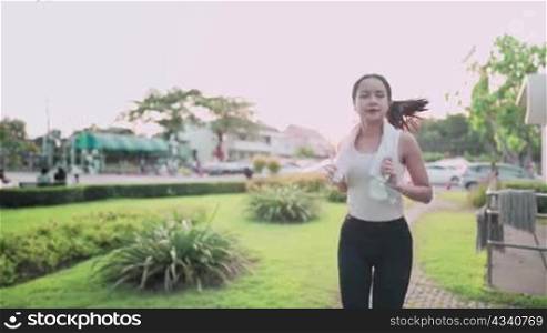 Young asian female running inside the park during sunset golden hour, healthy modern woman lifestyle, sport motivation self effort, weight loss work out routine, nutrition calories intake control