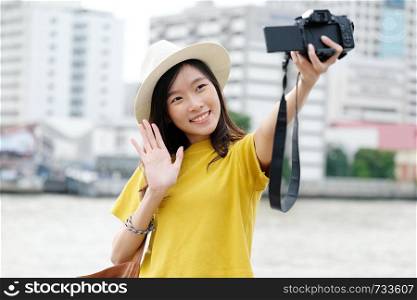 Young asian female traveler taking selfie photo in city outdoors background, Travel blogger, vlog concept