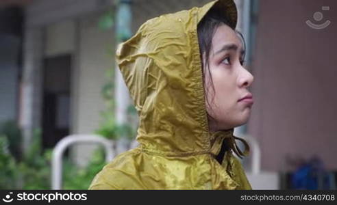 young asian female wear yellow hoody raincoat feeling down disappoint with rains pouring, rainy season weather, feeling blue sad and lonely, Bad stormy worried anxious stuck in the rain, wet clothes