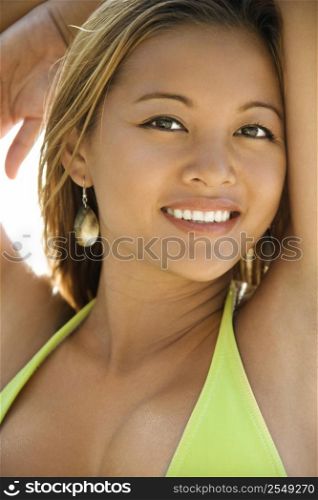 Young Asian Filipino adult female in swimsuit looking at viewer smiling.