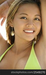 Young Asian Filipino adult female in swimsuit looking at viewer smiling.
