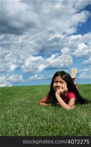 Young asian girl lying in the grass