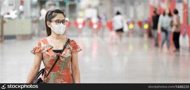 young Asian girl wearing Surgical face mask protect coronavirus inflection, Happy tourist woman walking in public subway station. social distancing, new normal and life after covid-19 pandemic