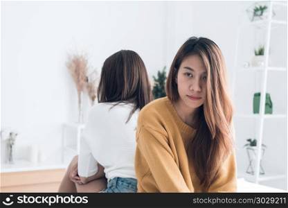 Young Asian lesbian couple argue and turn their back to each oth. Young Asian lesbian couple argue and turn their back to each other in the period of sad in the bedroom. LGBT couple sulky to another in the bedroom with a sad mood. LGBT lover emotion concept.