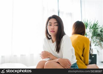 Young Asian lesbian couple argue and turn their back to each oth. Young Asian lesbian couple argue and turn their back to each other in the period of sad in the bedroom. LGBT couple sulky to another in the bedroom with a sad mood. LGBT lover emotion concept.