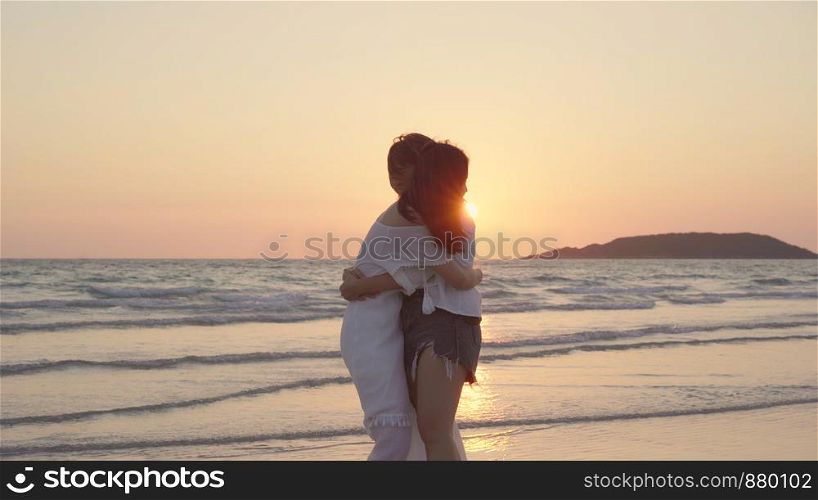 Young Asian lesbian couple running on beach. Beautiful women friends happy relax having fun on beach near sea when sunset in evening. Lifestyle lesbian couple travel on beach concept.