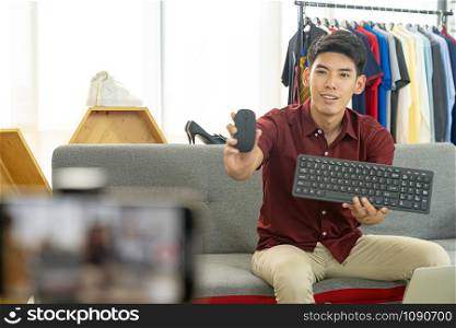 Young asian male online merchant blogger using smart mobile phone to recording live vlog video for review IT product goods. Online influcencer on social media concept.