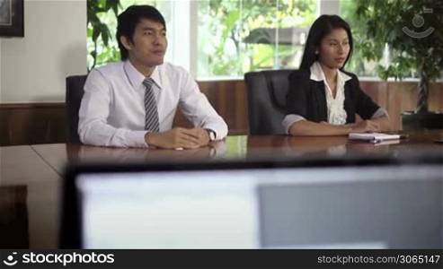 Young Asian man and woman at meeting for job interview. Dolly shot