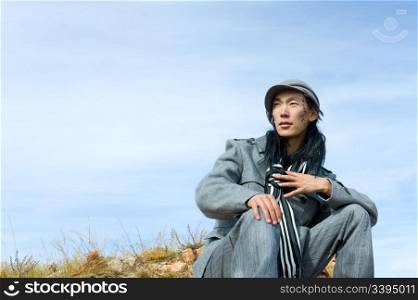 Young asian man demonstrating autumn fashion wear. The tracery on his cheek is his name Chinghis in ancient Mongolian.