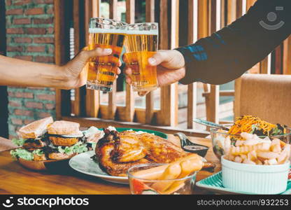 Young asian man drinking beer and clink glasses happy while enjoying home party