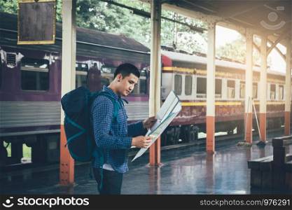 Young asian man holding map paper and looking route with plan for travel.