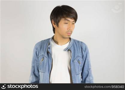 Young Asian Man in Jeans Jacket or Denim Jacket Looking Below. Denim or Jeans Jacket Men Fashion on Gray Background