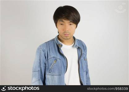 Young Asian Man in Jeans Jacket or Denim Jacket Looking Below at Front View. Denim or Jeans Jacket Men Fashion on Gray Background