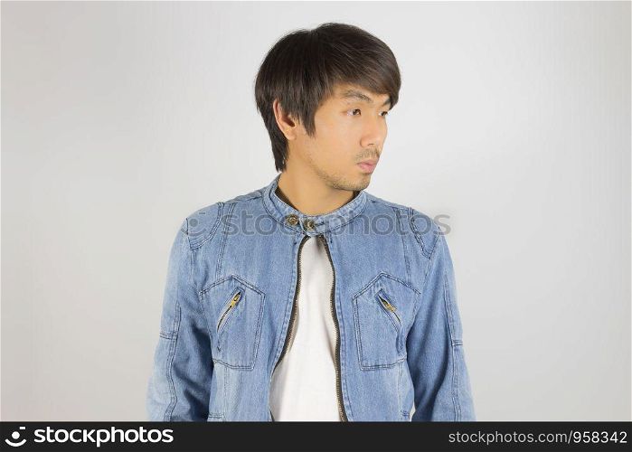 Young Asian Man in Jeans Jacket or Denim Jacket Looking Right Frame Pose. Denim or Jeans Jacket Men Fashion on Gray Background
