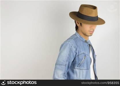Young Asian Man in Jeans Jacket or Denim Jacket Wear Hat on Right Frame. Denim or Jeans Jacket Men Fashion on Gray Background