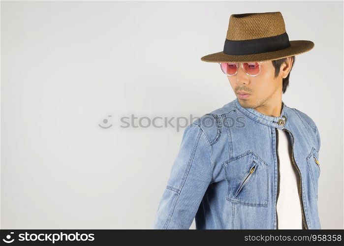 Young Asian Man in Jeans Jacket or Denim Jacket Wear Red Glasses and Hat at Right Frame. Denim or Jeans Jacket Men Fashion on Gray Background