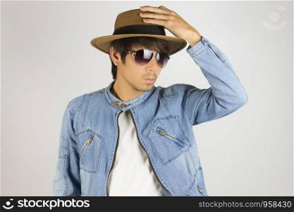Young Asian Man in Jeans Jacket or Denim Jacket Wear Sunglasses and Touch Hat. Denim or Jeans Jacket Men Fashion on Gray Background
