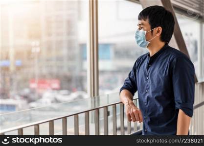 young asian man wearing medical mask for prevention from coronavirus (Covid-19) pandemic in the city. new normal concepts