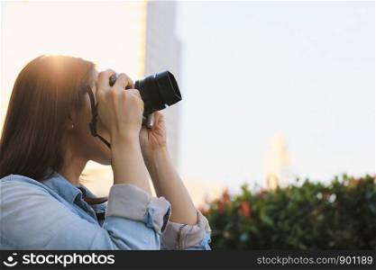 Young asian millennial woman in casual clothes taking photos of the city and enjoying her vacation, travel and lifestyle concept