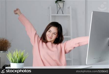 Young asian office woman stretching body for relaxing while working with computer at her desk, office lifestyle, business situation