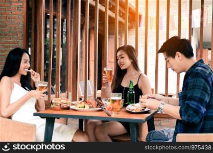 Young asian people having fun weekend at drinking with beer at restaurant.