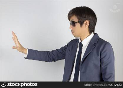 Young Asian Portrait Businessman in Navy Blue Suit with Stop Hand Pose on Grey Background
