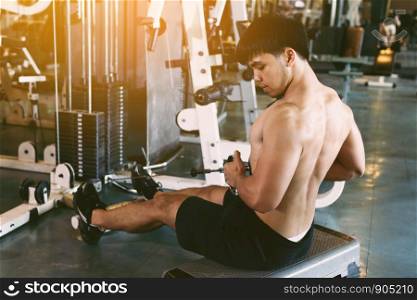 Young asian sportsman pull still weight for building muscle at indoor gym.