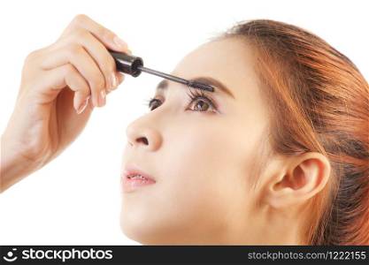 Young asian woman applying mascara on her long eyelashes isolated on white background