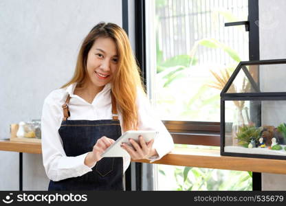 Young asian woman, barista, using tablet at cafe counter background, food and drink concept