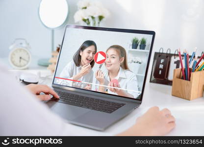 Young Asian woman beauty vlogger video online is showing make up on cosmetics products and live video on laptop. e-learning concept.