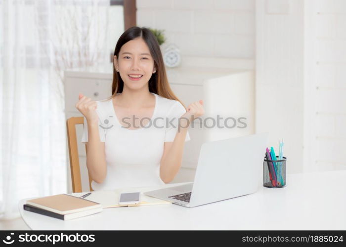 Young asian woman confident working at home with laptop computer and thinking idea for planning, freelance happy girl excited and success using notebook thoughtful and writing, business concept.