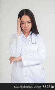 Young Asian woman doctor standing and holding hands in the head Due to headache, she looks unhappy and tired because of overwork, Concept of stressed and doctor liability, Dealing with frustrated