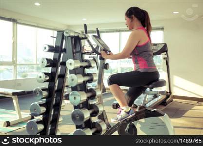 Young asian woman doing sport in the gym for fitness