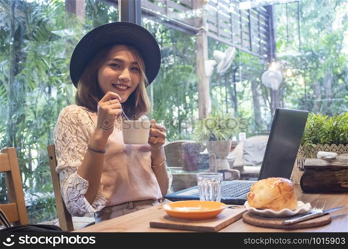 Young asian woman drinking coffee in a cafe