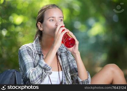 young asian woman drinking water in the forest