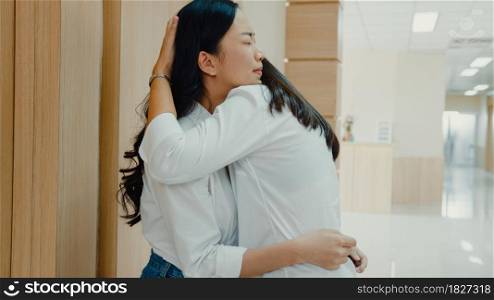 Young Asian woman embracing her mother and crying after get bad news from doctor about her father at hospital, Women cry wait for surgical operator feel sad and hopeless in front of emergency room.